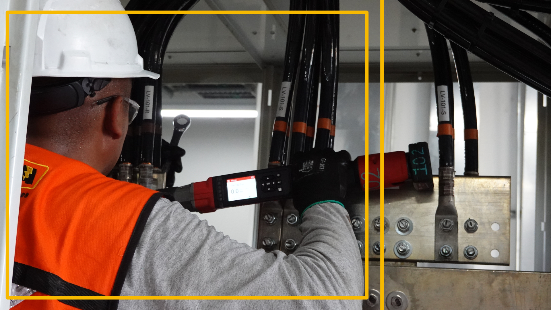 Un hombre con un chaleco naranja está trabajando con cables eléctricos.