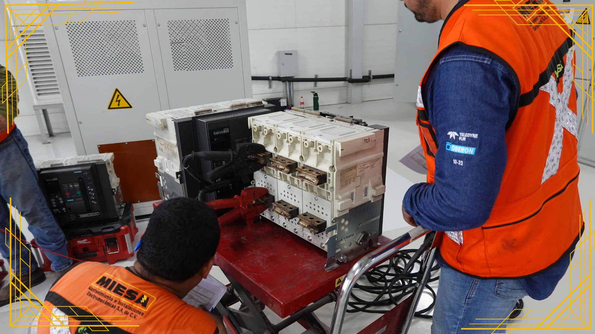 Dos hombres con chalecos naranjas están trabajando en una máquina.