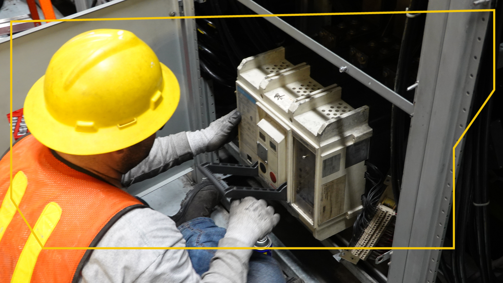 Un hombre que lleva un casco amarillo y un chaleco naranja está trabajando en una máquina.