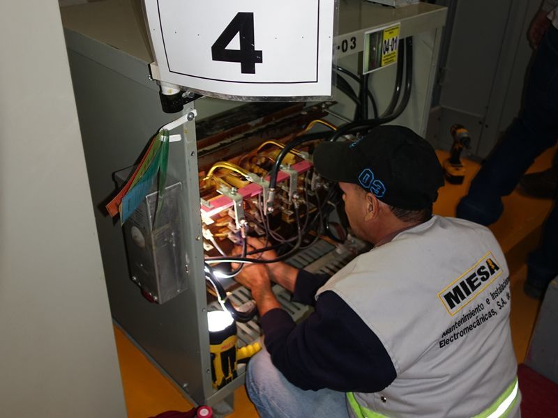 Un hombre con una camisa de Miesa está trabajando en una máquina.