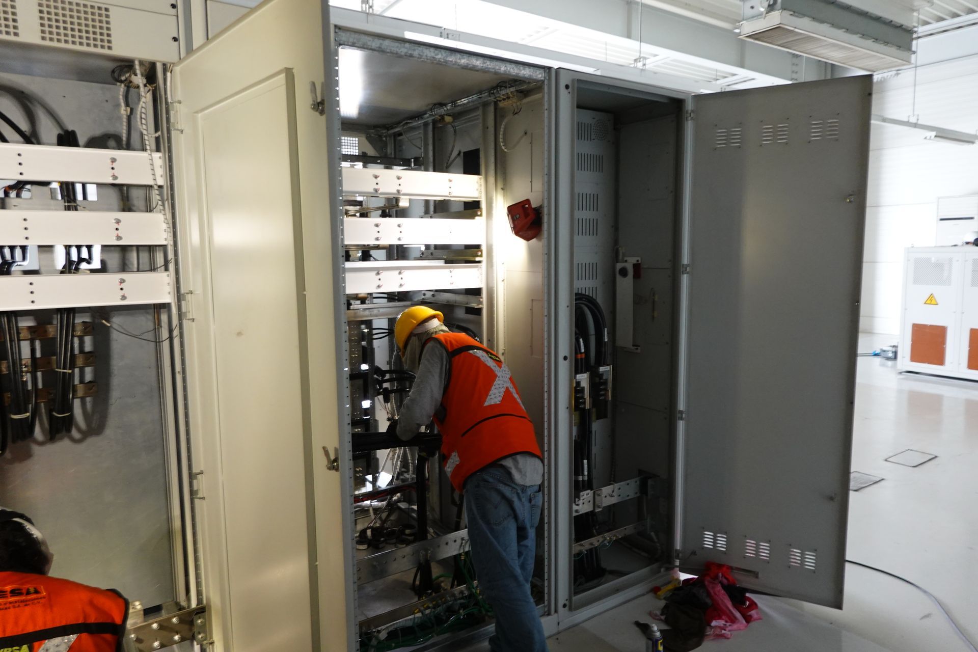 Un hombre está trabajando en una caja eléctrica en una habitación.