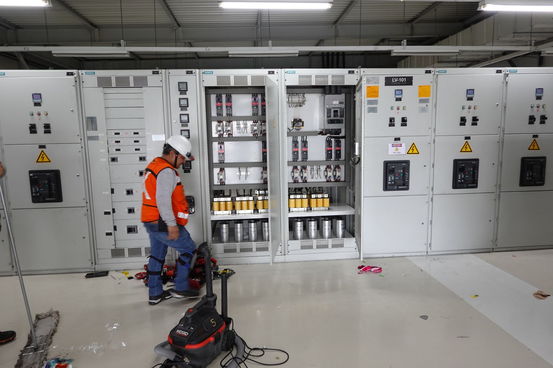 Un hombre está trabajando en un panel eléctrico en una habitación.