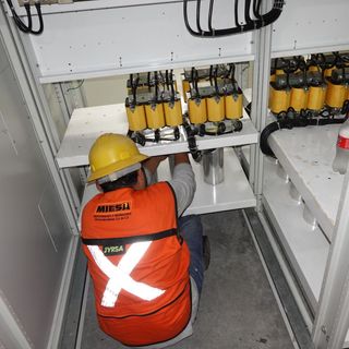 Un hombre que lleva un chaleco naranja con una x en la espalda.