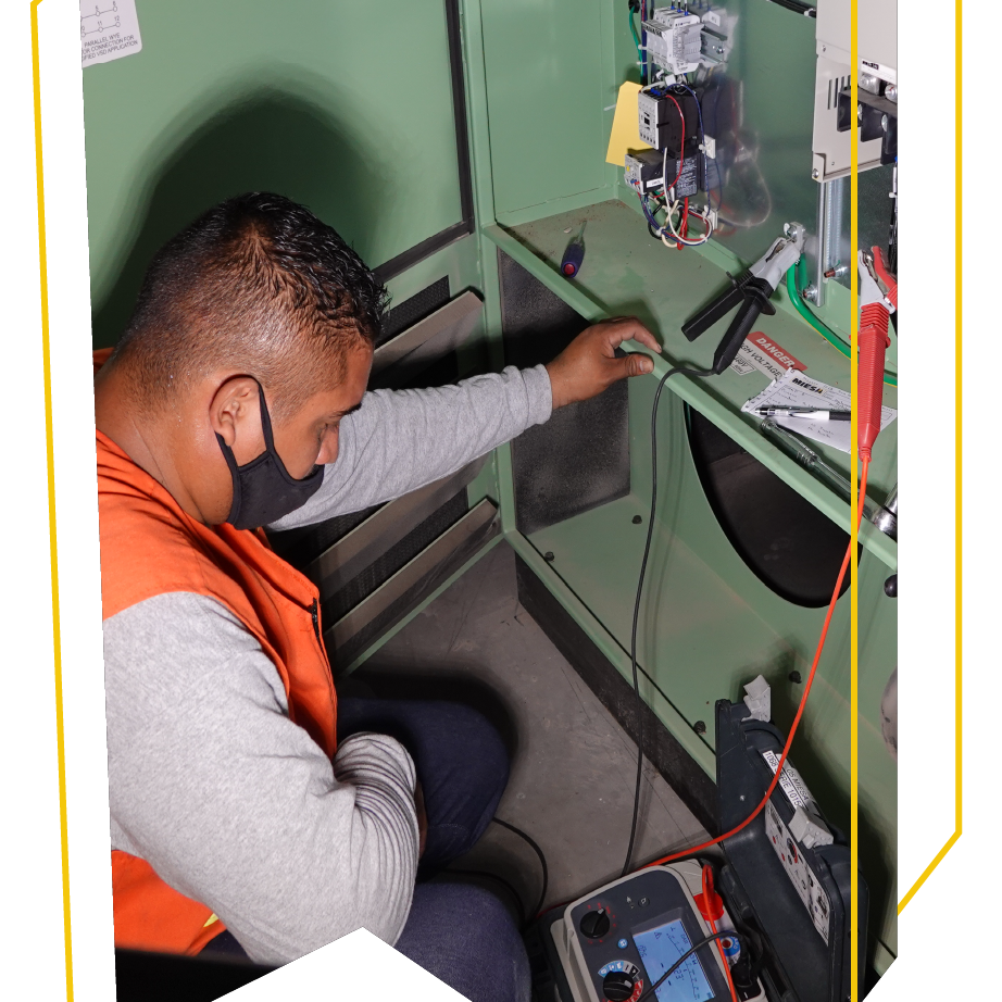 Un hombre que lleva una máscara está trabajando en una máquina.