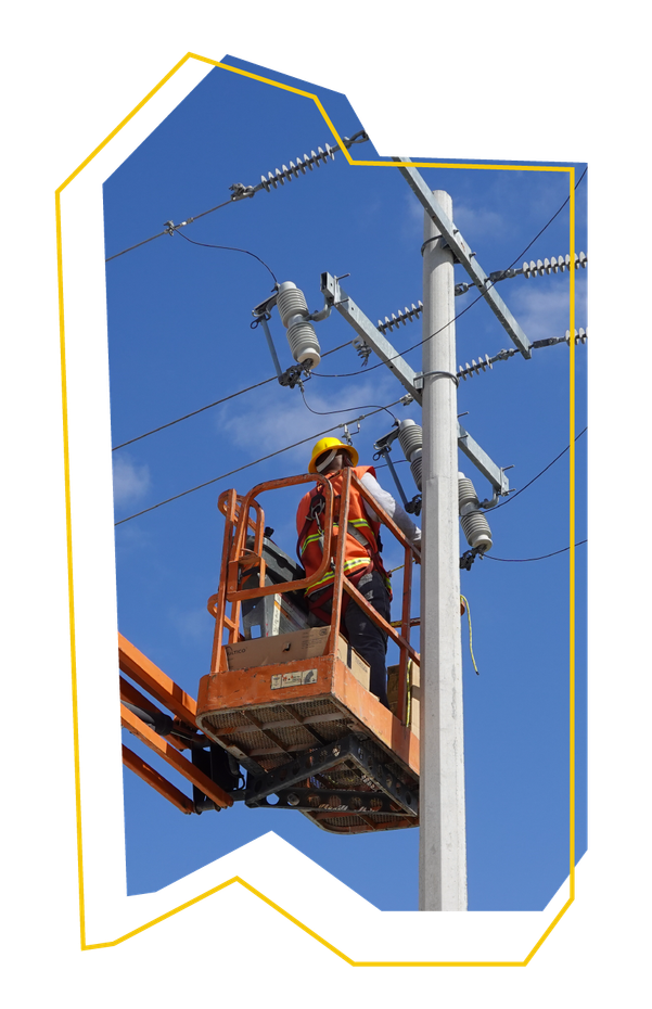 Un hombre en un balde está trabajando en un poste de electricidad.
