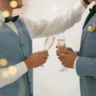 Two men in suits are toasting with champagne glasses.