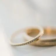 A close up of a pair of wedding rings on a table.