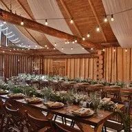 A large room with tables and chairs set up for a wedding reception.