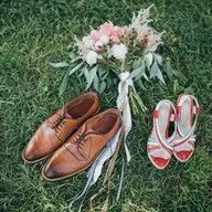 A pair of shoes , a bouquet of flowers and a pair of shoes are sitting on the grass.