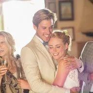 A bride and groom are hugging each other at their wedding reception.