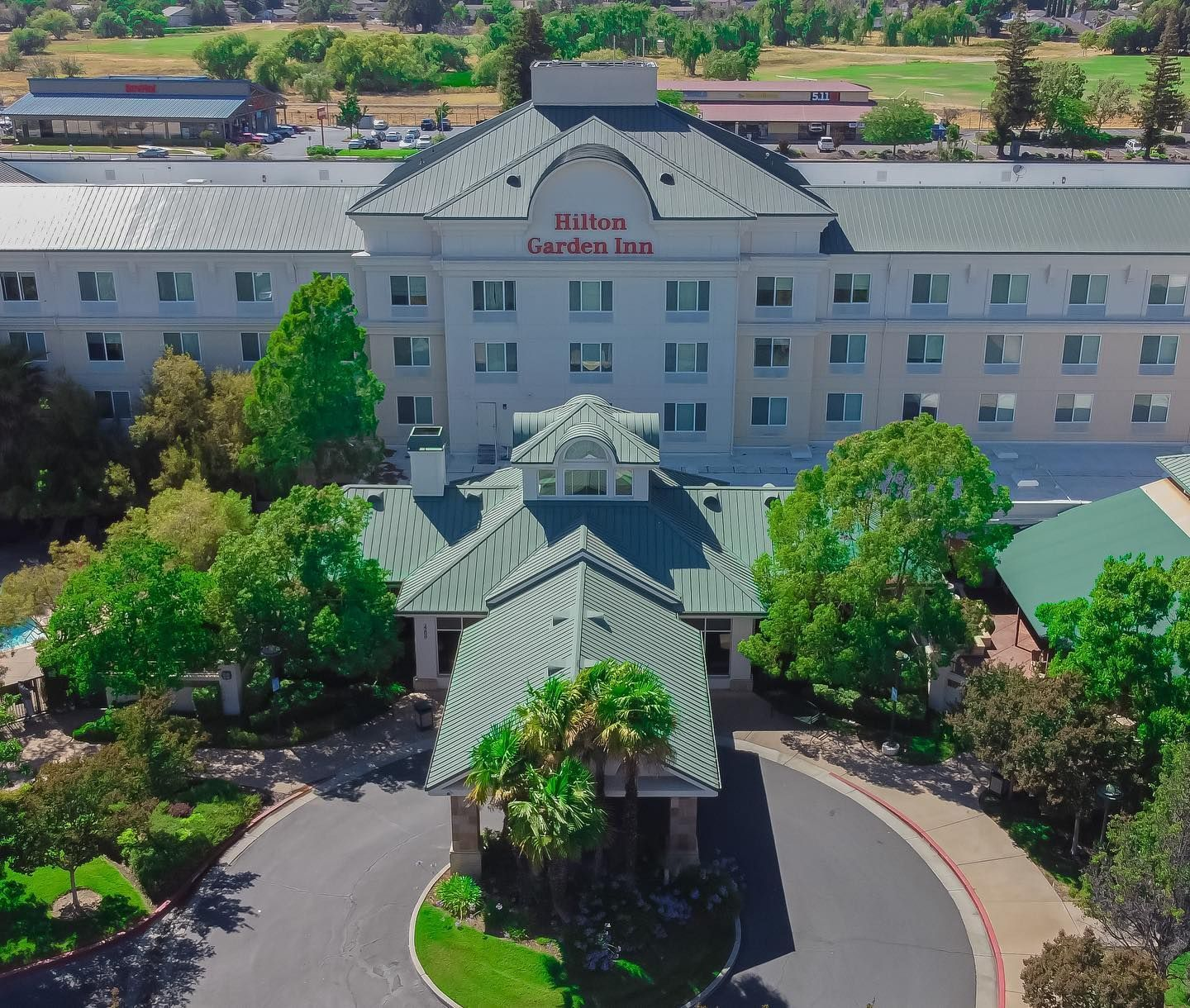 An aerial view of a large hotel with a green roof