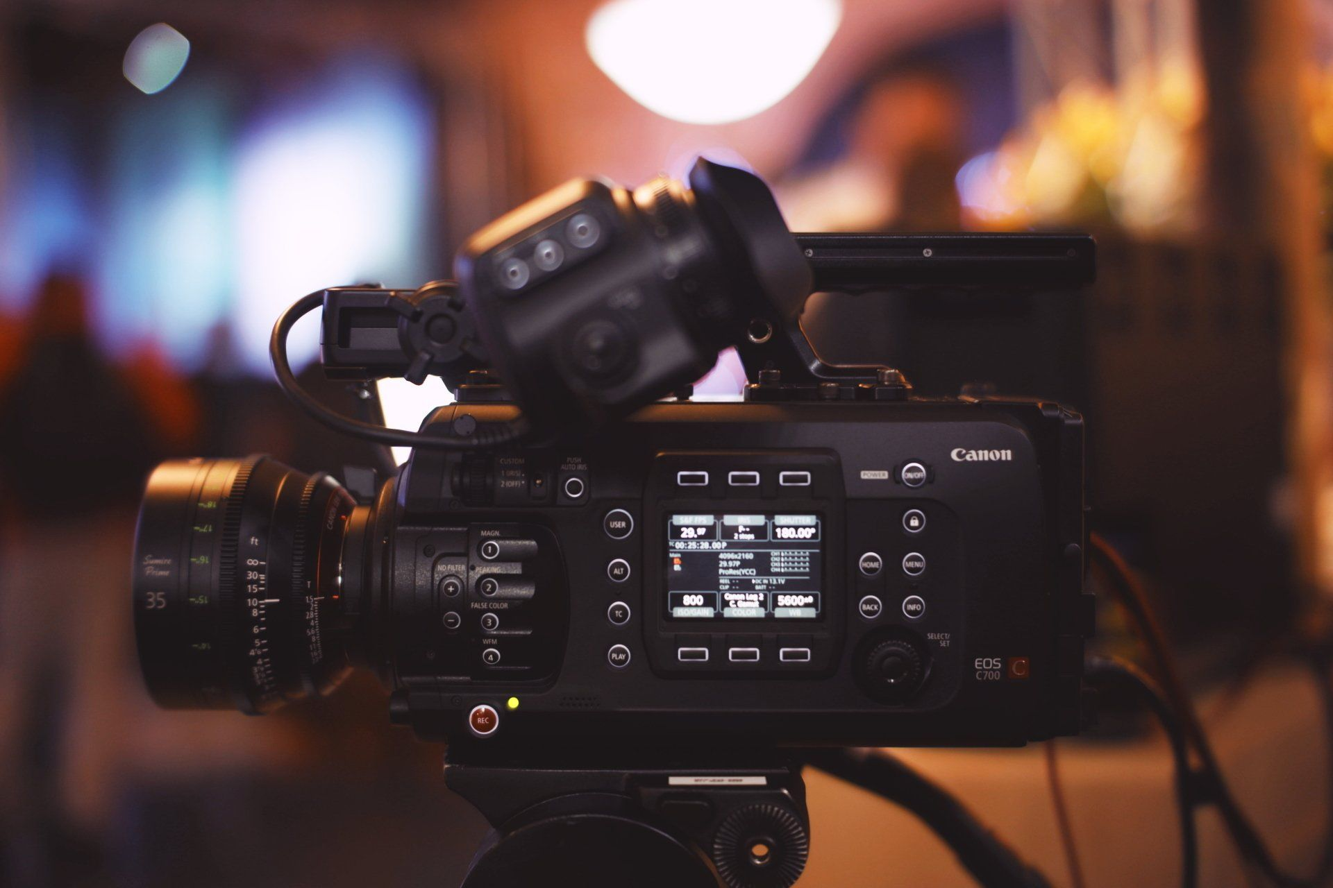 A close up of a video camera on a tripod.