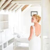 A woman in a white dress is standing in a room.