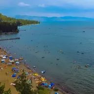 An aerial view of a beach surrounded by water and mountains.
