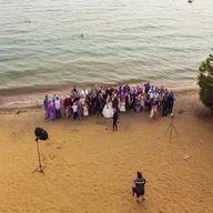 A group of people are posing for a picture on a beach.