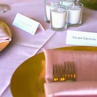 A table setting with a plate , napkin , fork and candles.