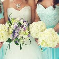 A bride and her bridesmaids are holding bouquets of flowers.