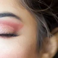 A close up of a woman 's face with her eyes closed.