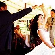 A bride and groom are dancing at their wedding reception.