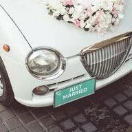 A white wedding car with a license plate that says `` just married ''.