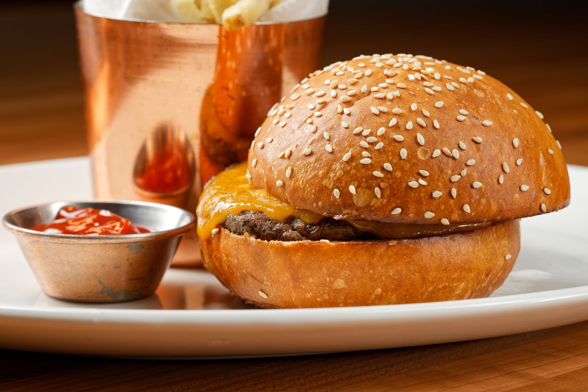 A hamburger and french fries on a plate with ketchup.