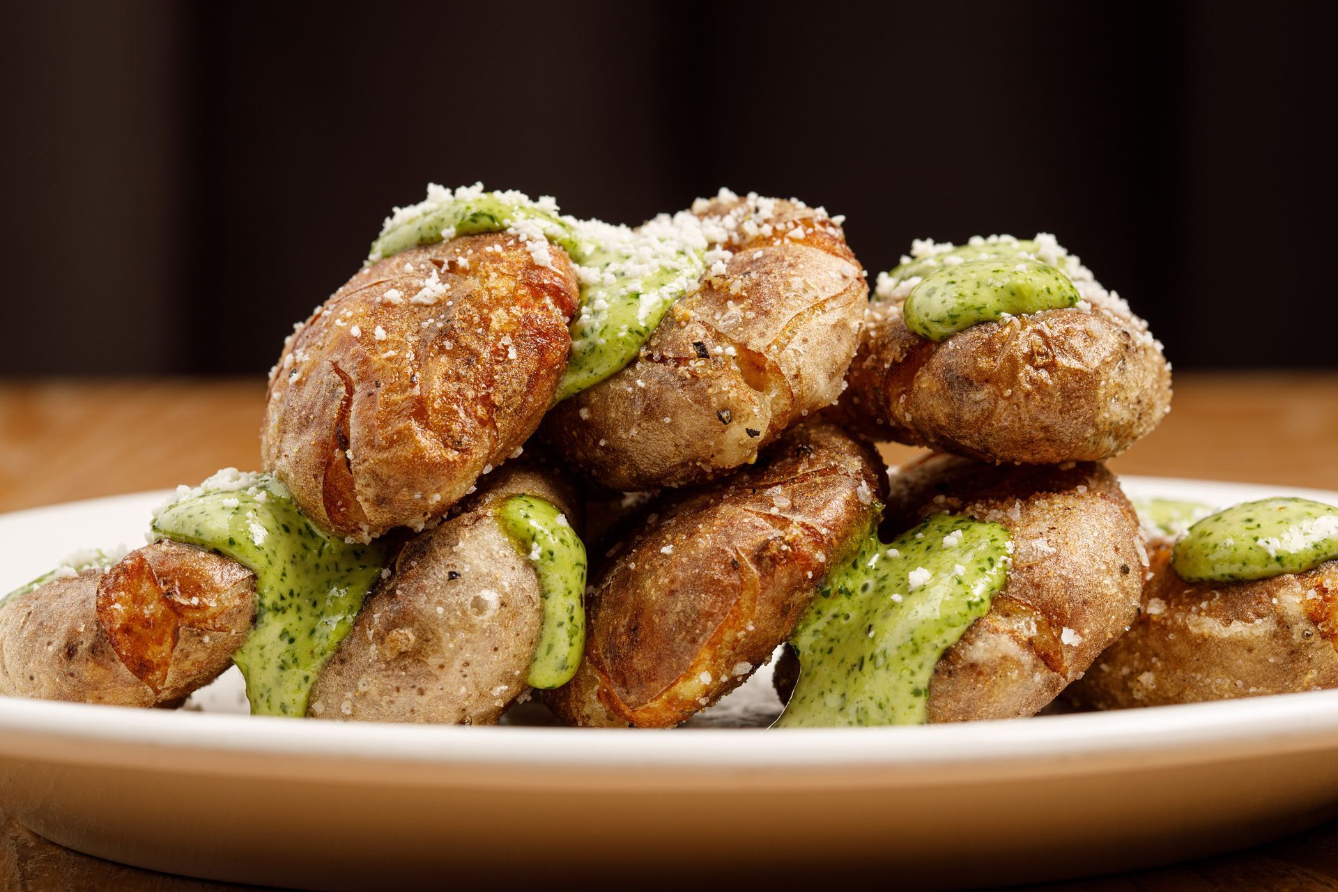 A plate of food with meatballs and green sauce on a table.