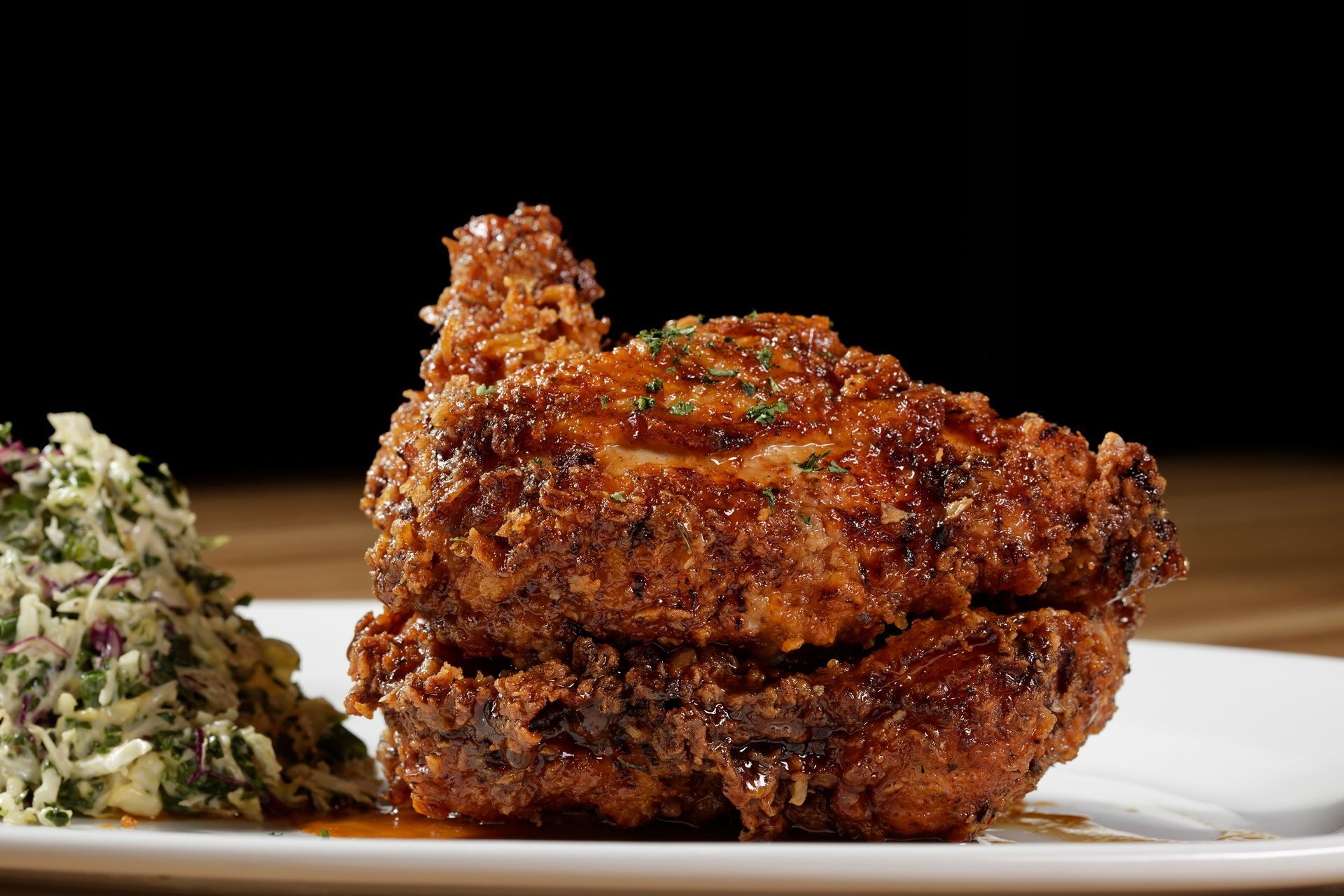 A white plate topped with fried chicken and coleslaw.