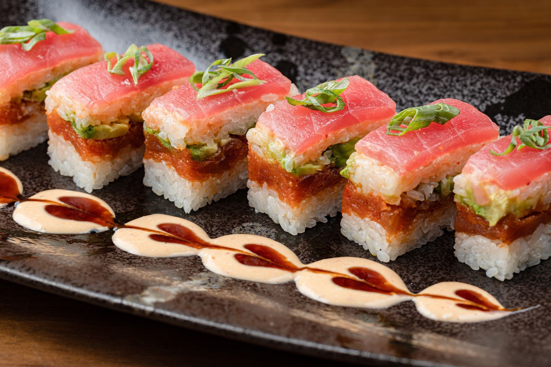 A close up of a plate of sushi on a table.