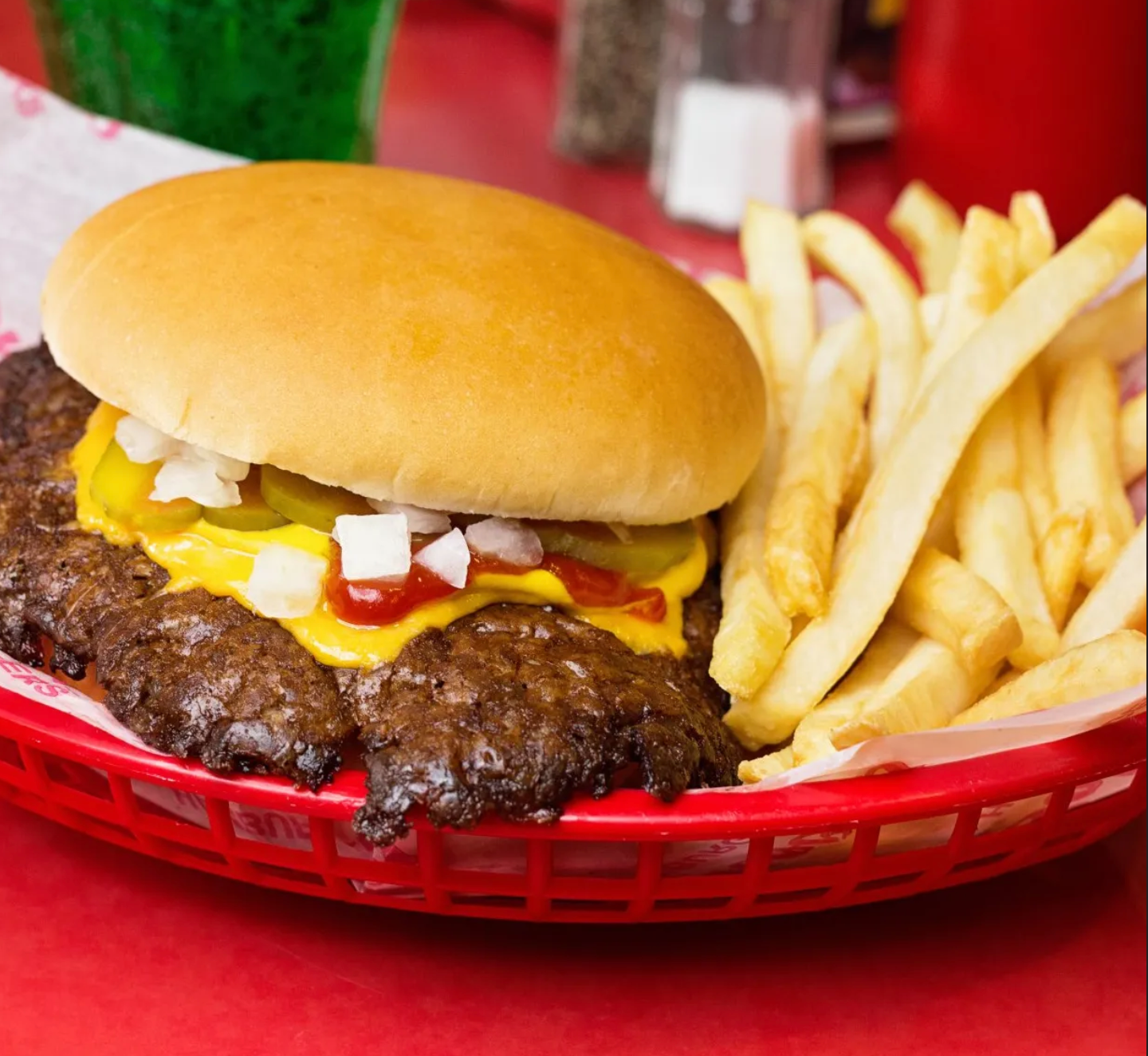 A hamburger and french fries in a red basket