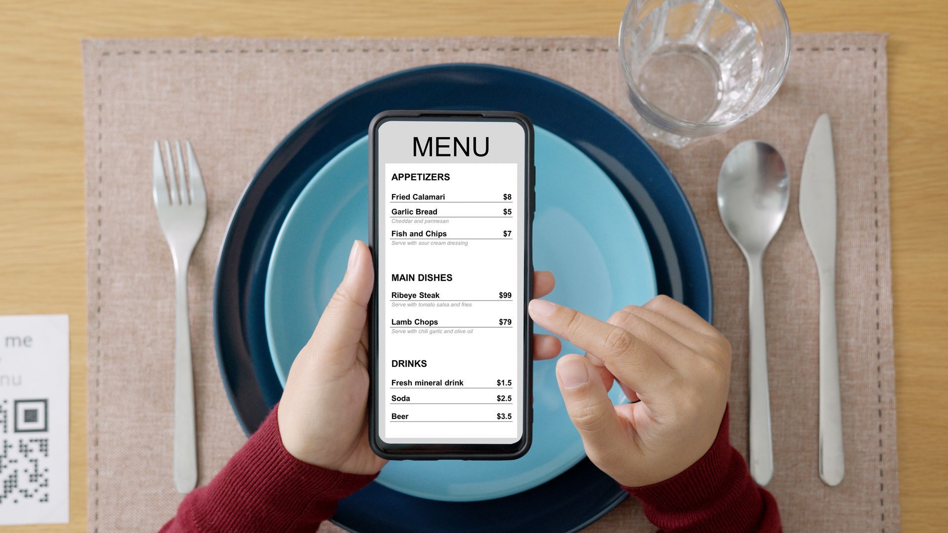 A person is holding a cell phone with a menu on the screen.