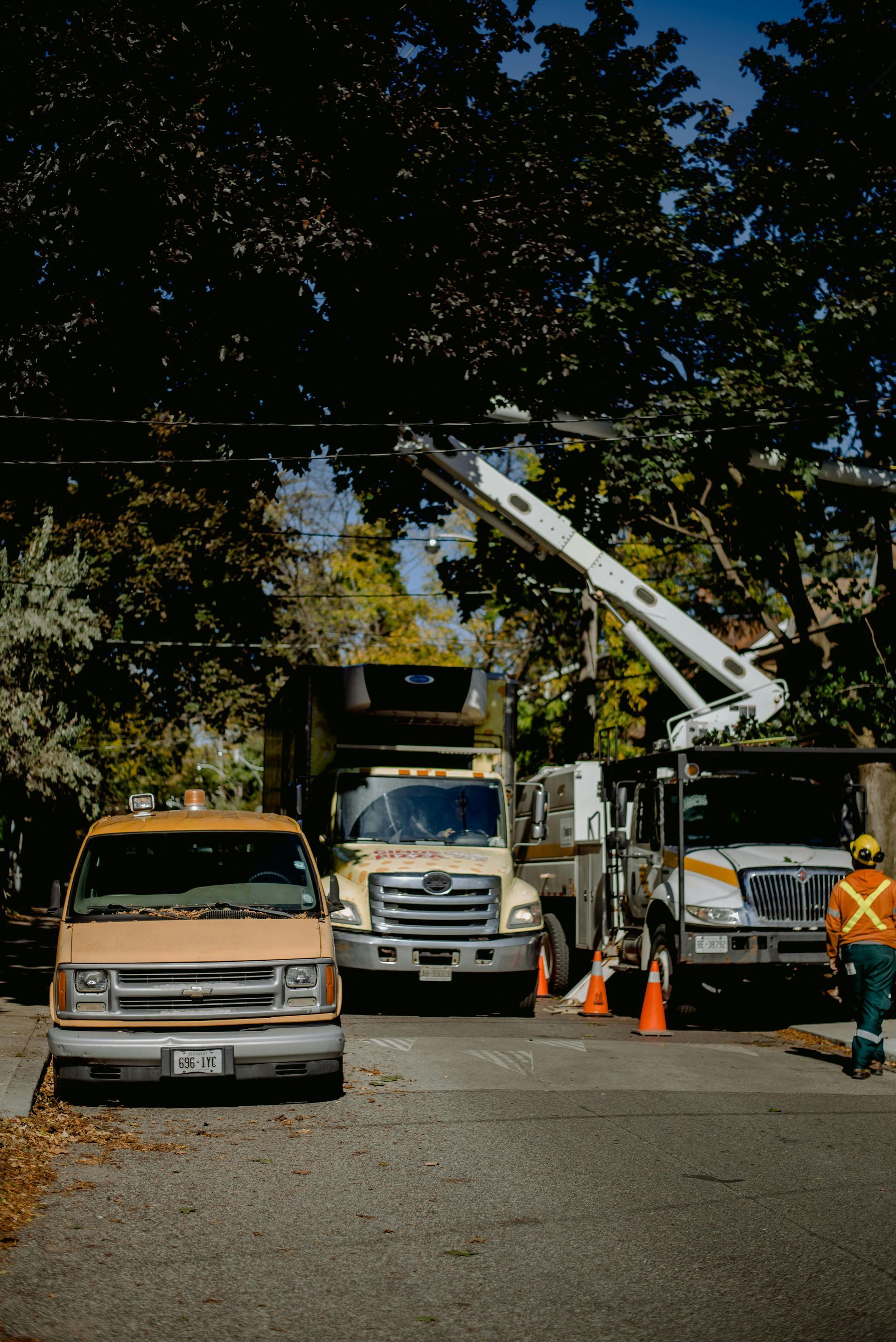 Three trucks are parked on the side of the road.