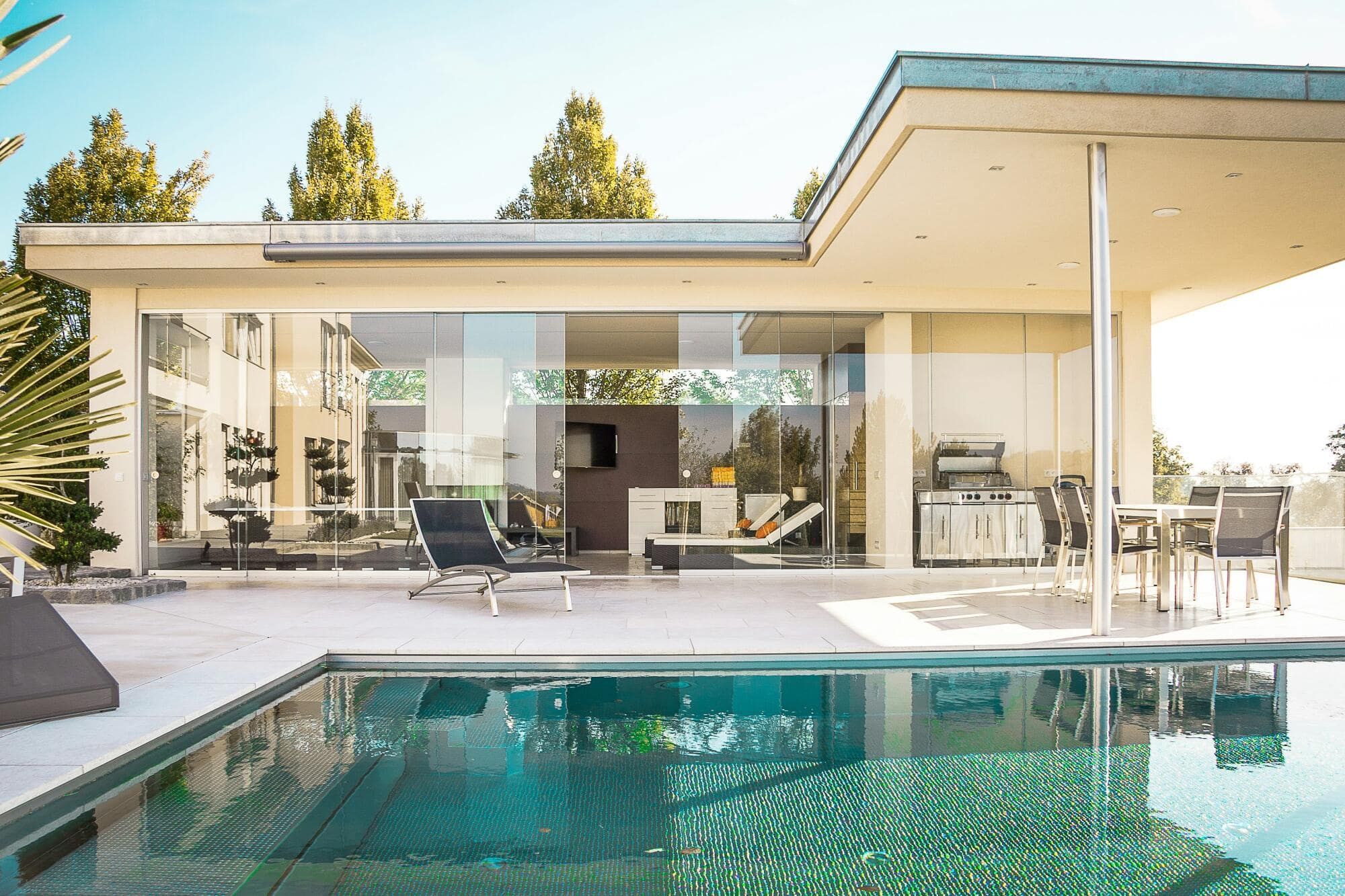 A house with a swimming pool in front of it.