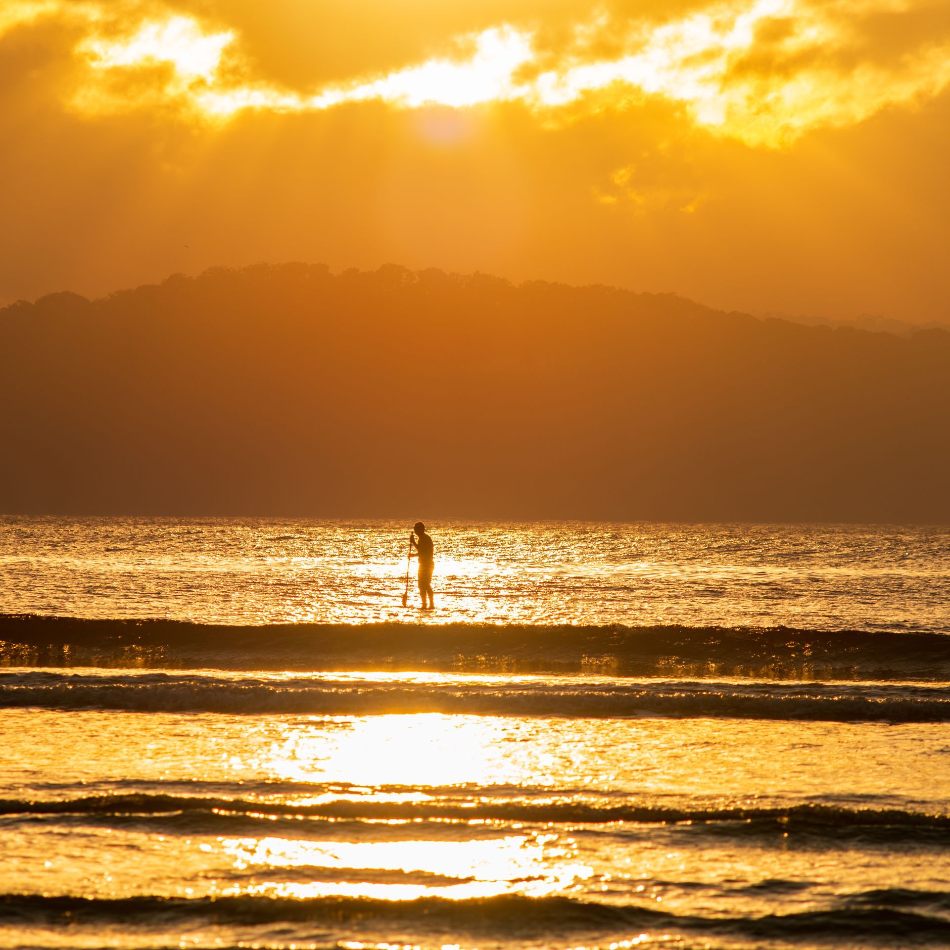 Silhouette of person paddleboarding on ocean at sunset. — GMS Legal & Conveyancing In 38 Canton Beach Rd Toukley, NSW