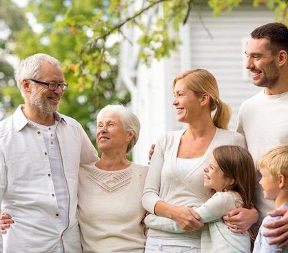 Family of six smiling, embracing outdoors in front of a house.  GMS Legal & Conveyancing In 38 Canton Beach Rd, Toukley