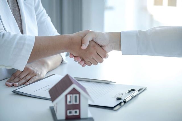 Two People Shaking Hands Over Documents — GMS Legal & Conveyancing In 38 Canton Beach Rd, Toukley