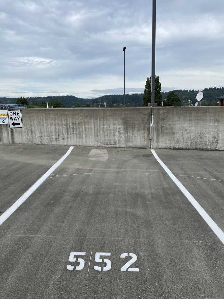 Empty parking space marked 552 beside a concrete wall on an overcast day.