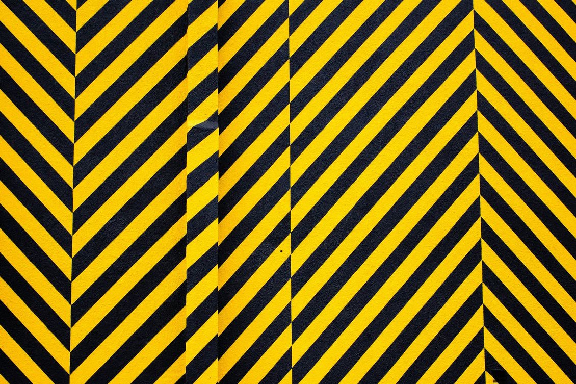 Yellow and black diagonal hazard stripes with a central vertical bar