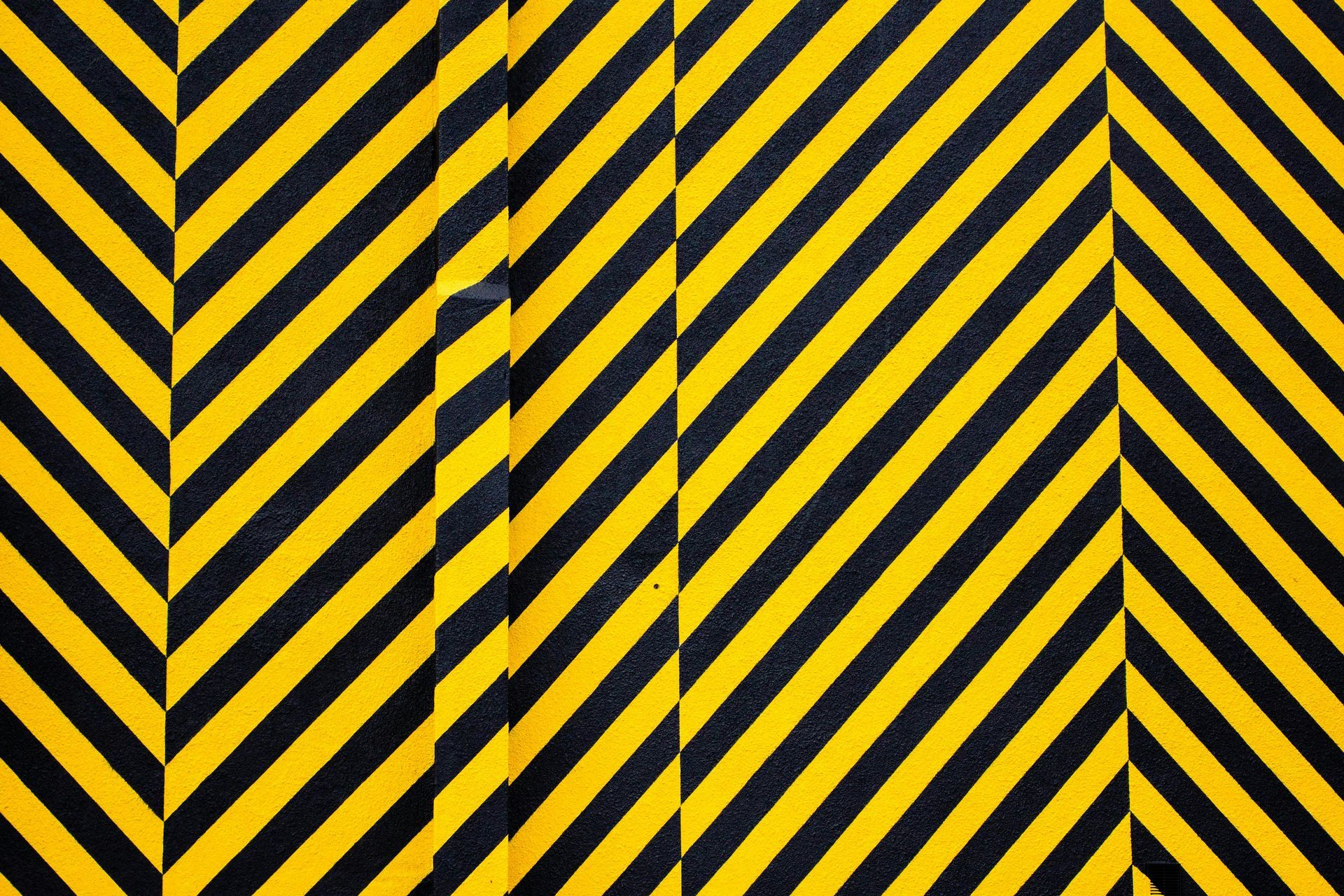 Yellow and black diagonal hazard stripes with a central vertical bar