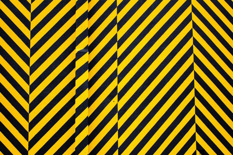 Black and yellow diagonal hazard stripes with a vertical white-striped panel in the center