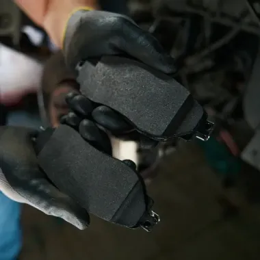 Gloved hands holding two black rectangular electronic components up close