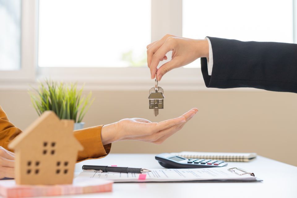 agent giving  house key to the owner
