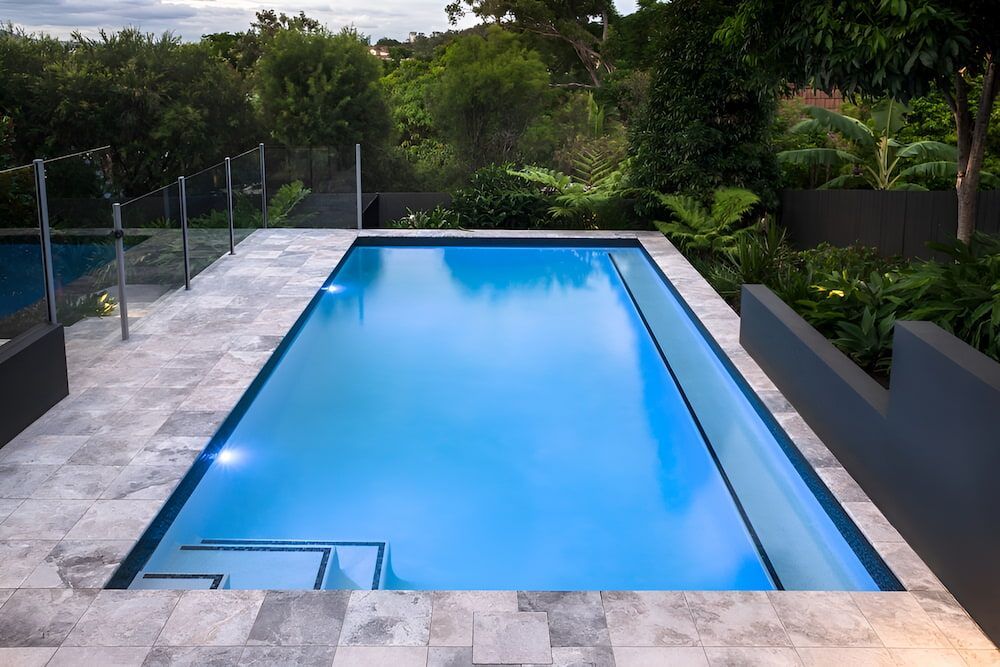 A Large House With a Swimming Pool in Front of It — Aqualine Pools in Innes Park, QLD