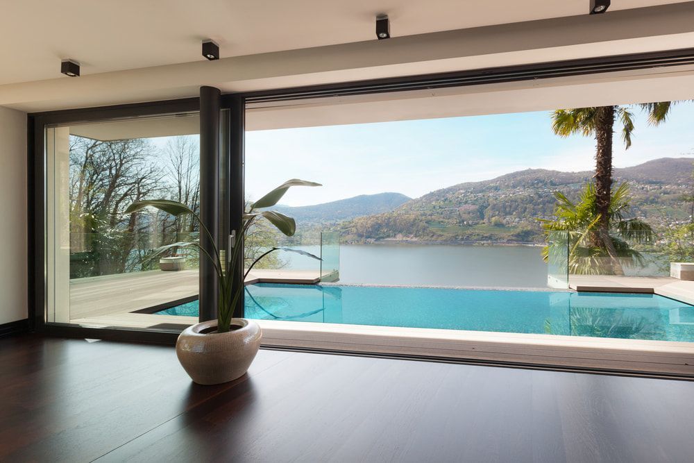 A Swimming Pool is Visible Through a Large Window in a House — Aqualine Pools in Kalkie, QLD
