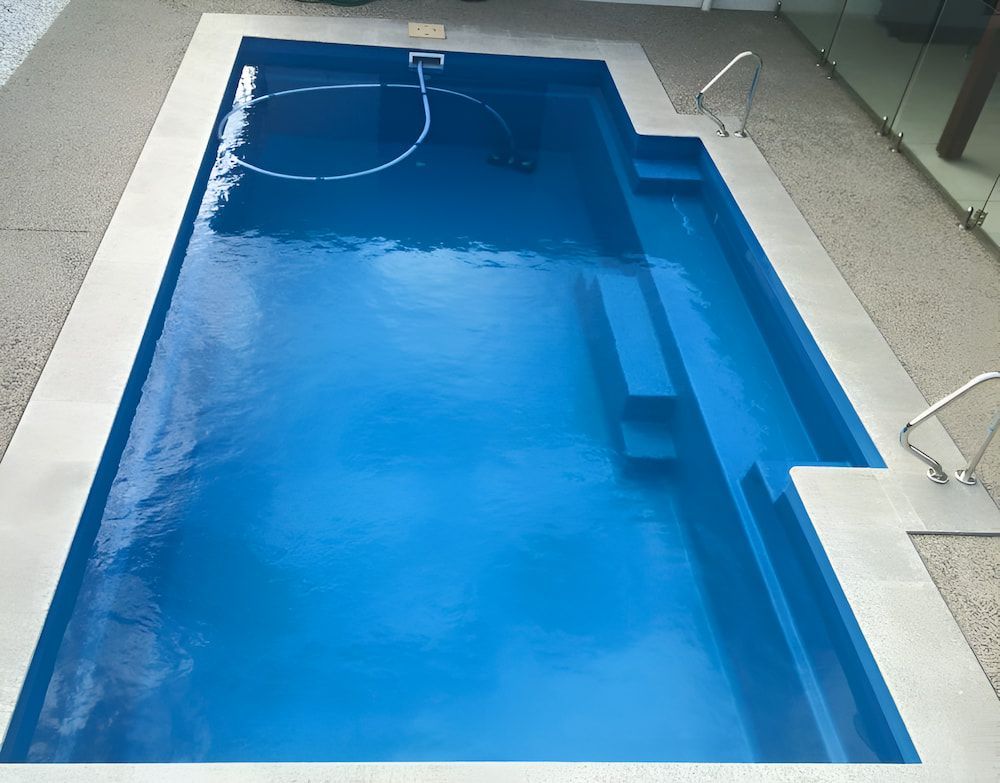 A Large Blue Swimming Pool With a White Border — Aqualine Pools in Branyan, QLD