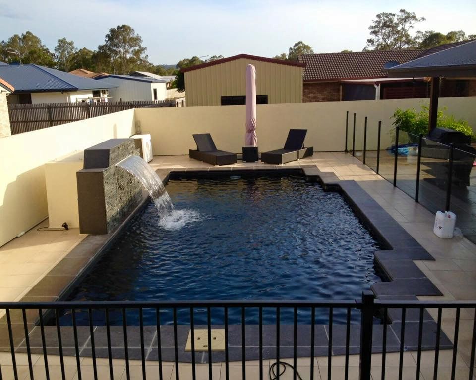 A Large Blue Swimming Pool With a Fence Around It — Aqualine Pools in Branyan, QLD