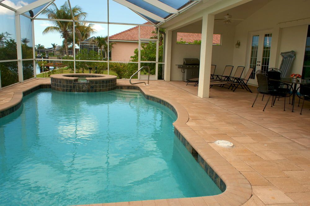 A Large Swimming Pool is Surrounded by a Screened in Area — Aqualine Pools in Kalkie, QLD