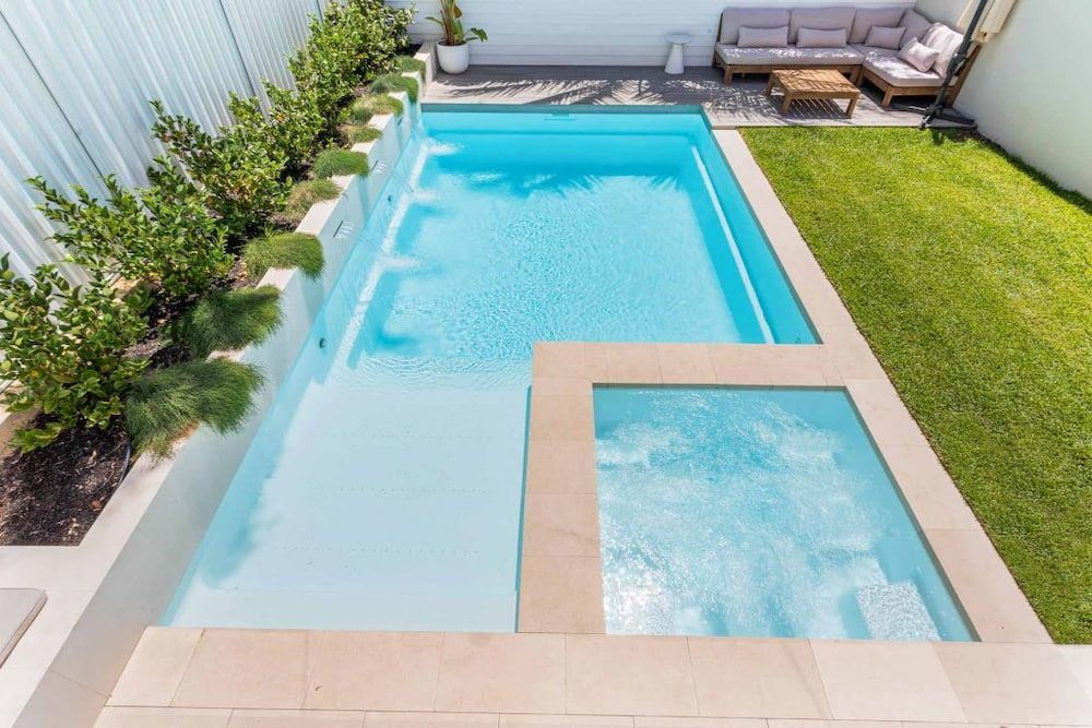 Man is Cleaning an Empty Swimming Pool With a High Pressure Washer — Aqualine Pools in Coral Cove, QLD