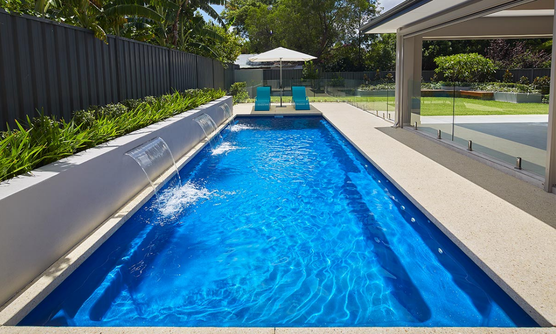 A Large Swimming Pool With 2 Deckchairs — Aqualine Pools in Kalkie, QLD
