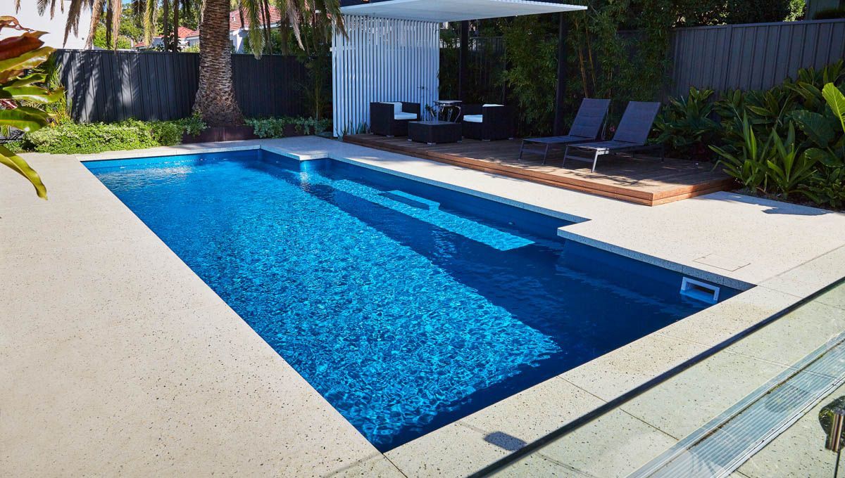 A Large Swimming Pool With Sitting Area— Aqualine Pools in Coral Cove, QLD