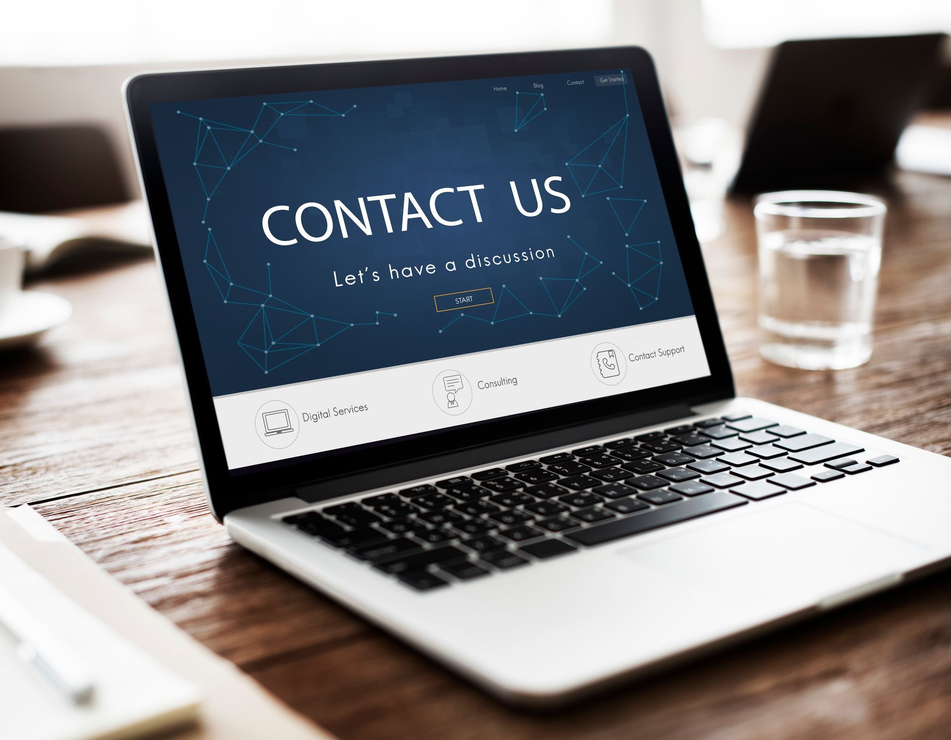 A laptop computer is open to a page that says contact us